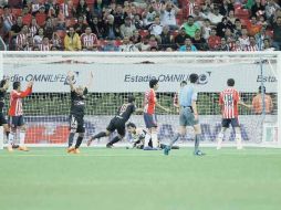 Luis Michel yace en el césped tras haber originado el primer gol de Xolos; Atras, la afición, no lo puede creer.  /