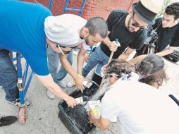 El artista urbano francés JR (de sombrero), en el Bronx, en julio de 2011. ESPECIAL  /