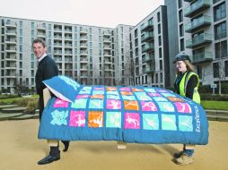 El británico Matthew Pinsent ayuda a los operarios a cargar las primeras camas que se instalan en la Villa. GETTY IMAGES SPORT  /