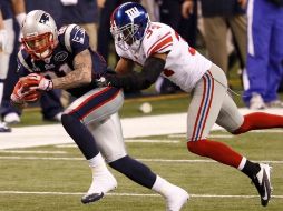 Aaron Hernández de los Patriotas se aleja de Dean Grant de los Gigantes durante el primer tiempo del Super Bowl XLVI. REUTEURS  /