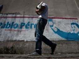 Un hombre pasa frente a una publicidad política del candidato presidencial venezolano Pablo Pérez ,en una calle de Caracas. EFE  /