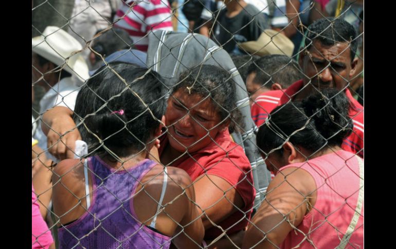 Familiares y amigos de las víctimas afuera de la prisión en Comayagua. AFP  /