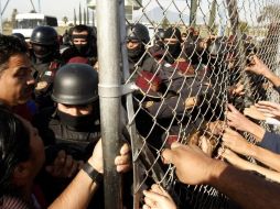 Familiares de prisioneros discuten con fuerzas de seguridad en el penal de Apodaca, luego del motín. AFP  /