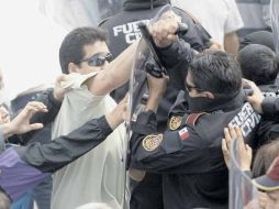 Fuera del penal de Apodaca hubo forcejeos entre parientes de los presos que intentaban ingresar y los policías que lo prohibían. AFP  /