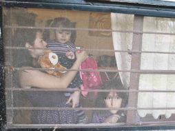 Acompañada por una sobrina, Nayeli Hernández carga a su hija Leonor, a la que intentó inscribir en primero de preescolar.  /