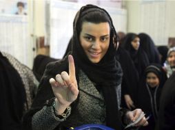 Una mujer iraní muestra su dedo marcado con tinta tras haber votado en las elecciones legislativas celebradas hoy. EFE.  /