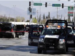 Policías Estatales y Federales resguardan la esquina donde se dio uno de los enfrentamientos contra los criminales.  ARCHIVO  /