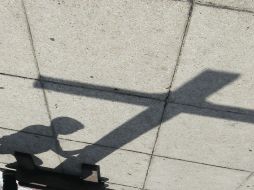 Silueta de joven que toca la cruz en el Monumento a la Revolución en Guanajuato.  /