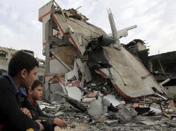 Dos jóvenes se sientan junto a las ruinas de la vivienda de un dirigente de la Yihad Islámica, tras un ataque aéreo israelí. EFE  /