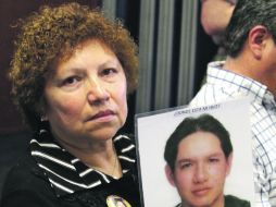 Una mujer muestra una fotografía con el rostro de su hijo del que nada sabe. NTX  /