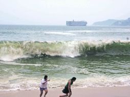 A CORRER.- Turistas “juegan” con el mar embravecido. EL UNIVERSAL  /