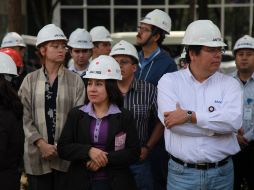 Trabajadores con cascos esperan afuera de un edificio en ciudad de México tras ser evacuados. AP  /
