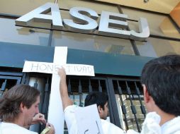 Los manifestantes pegaron sobre la puerta de la ASEJ cruces de papel con las palabras ''justicia, transparencia, democracia''.  /