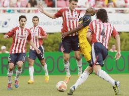 El defensor de Chivas Kristian Álvarez (centro) frena al atacante americanista Christian Benítez.  /