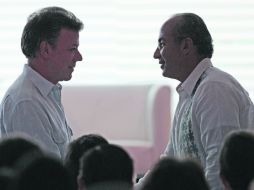 El Mandatario de Colombia, Juan Manuel Santos, saluda a su homólogo Felipe Calderón, antes de la plática ante empresarios. AP  /