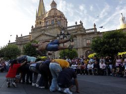 Ocho voluntarios del público en Plaza de Armas, arriesgan sus espaldas en espera de ser saltados.  /