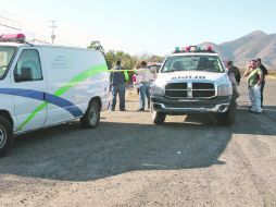 Policías de Acatlán de Juárez acordonan el área donde fue encontrado el cuerpo de un varón con múltiples impactos de bala.ESPECIAL  /