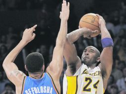 Kobe Bryant (der.) dispara a la canasta ante la marca deThabo Sefolosha. AP  /