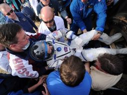 Personal de tierra ayuda al astronauta Dan Burbank tras el aterrizaje de la cápsula. AFP  /