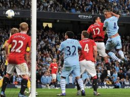 El jugador del Manchester City Vincent Kompany (d) cabecea el balón para anotar el único gol del encuentro. AP  /