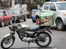 La motocicleta del repartidor impactó por un costado a un auto, rebotó y fue atropellado por un camión de volteo.  /