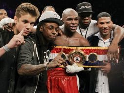 Después de la pelea, el cantante saltó al ring con los raperos 50 Cent y Lil Wayne. AP  /