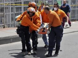 Rescatistas y agentes de corporaciones policiacas laboran en la zona del ataque para atender a los heridos. AFP  /