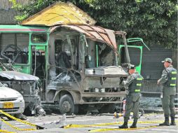 Oficiales de Policía inspeccionan los restos de los vehículos dañados tras detonar el explosivo. AFP  /