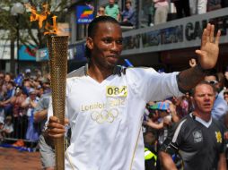 Fanáticos de Chelsea vitorearon al futbolista mientras corría por el centro de Swindon. AP  /