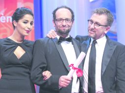 FELIZ. Carlos Reygadas (c) junto a la actriz Leila Bekhti y el director británico Tim Roth al recibir su reconocimiento. AGENCIAS  /