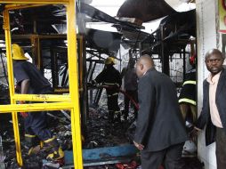 Bomberos kenianos y algunos oficiales de policía vestidos de civiles examinan el lugar de la explosión. AP  /