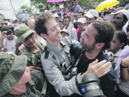 Romeo Langlois  (izq.) abraza al también periodista Carlos Villalón, de Chile, en San Isidro, en el Sur de Colombia. AP  /