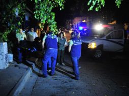 Elementos del IJCF levantan el cuerpo de un hombre en una bolsa negra. ESPECIAL  /