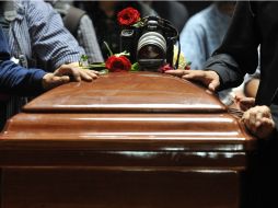 En la despedida el féretro del fotoperiodista Hector García fue cubierto de rosas blancas, rojas y una cámara fotográfica. EFE  /