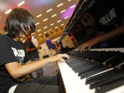 Un joven toca el piano en uno de los stands de la feria que hoy concluye su segunda edición.  /