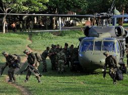 Soldados colombianos transportando armamento decomisado y los cuerpos de guerrilleros de las FARC. EFE  /