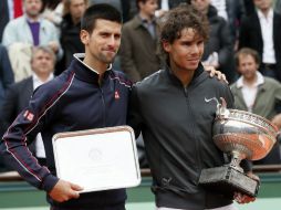 Los tenistas Rafael Nadal (d) y Novak Djokovic (i), con sus respectivos trofeos en Roland Garros. AFP  /