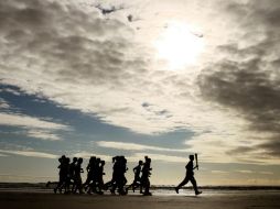 El joven británico Joseph Forrester, de 13 años, transportó la antorcha en la playa junto al grupo de niños. AP  /