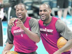 Dwyane Wade y LeBron James bromean con un camarógrafo durante la práctica. AP  /