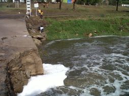 Mientras el cauce recibe descargas de aguas negras, un niño se acerca a éste para rescatar su balón de futbol.  /