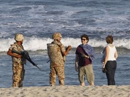 Agentes de la Marina resguardan las playas; dialogan con paseantes. REUTERS  /