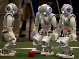 Robots deportistas que se mueven en pequeñas canchas de fútbol bajo la coordinación de científicos, en la 'Liga Humanoide'. AP  /