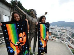 Fans del cantante posan en una estatua inspirada en él en una favela de Río de Janeiro. AFP  /