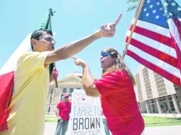 Andy Hernández, con una Bandera mexicana, y Allison Culver, con una bandera de EU, discuten sobre la Ley Antiinmigrante SB1070. AP  /