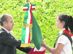 Felipe Calderón entrega el Lábaro Patrio a la taekwondoín María del Rosario Espinoza durante la ceremonia en Los Pinos. AP  /