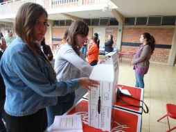 Una funcionaria de casilla prepara la urna, al inicio de la jornada electoral de hoy, en la sección 1155.  /