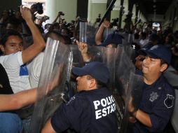 Agentes de policía intervienen durante un enfrentamiento entre varios hombres en una casilla en Xalapa, Veracruz. EFE  /