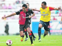 Sergio Santana (derecha), quien fue el autor de la única anotación rojinegra, pelea un balón con Aldo Leao, del Morelia. MEXSPORT  /