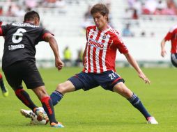Carlos Fierro lucha por el balón con el atlista Gregorio Torres, en el Clásico de ayer que terminó sin goles.  /
