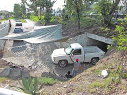Varias personas obtienen ingresos extra regulando el paso de vehículos por el improvsado túnel vehicular.  /